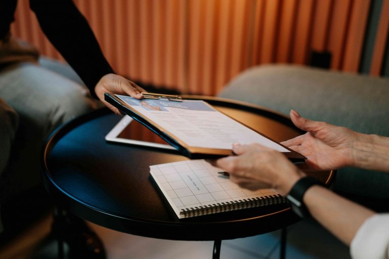 Sebuah tangan HRD menyambut CV dengan jabat tangan hangat—simbol awal hubungan yang bermakna. (Sumber: pexels/cottonbro studio)